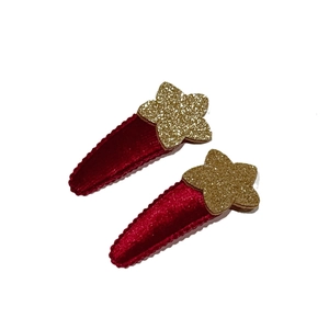 Paio di fermagli per capelli a carota in velluto rosso con stelle glitterate oro su bianco