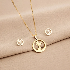 Close-up of golden geometric necklace and earrings set with butterfly motif in circles