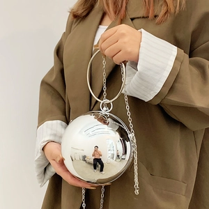 Silver spherical acrylic evening bag with metal ring handle and crossbody chain strap