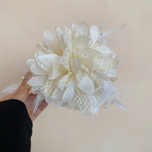 Detail of elegant lace flower hair claw with white feathers and pearl accents