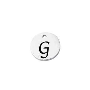 Detailed view of a silver mirror-finish stainless steel round charm with engraved letter G