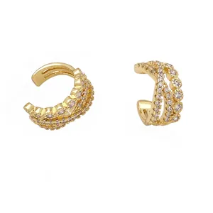 Crossed gold ear cuffs with micro-pave cubic zirconia stones on white background