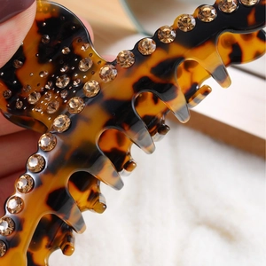 Leopard print hair claw clip with amber rhinestones for an elegant ponytail look