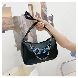 Detail of black PU leather underarm bag with silver chain and blue butterfly charms