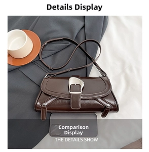 Detail of glossy brown leather shoulder bag with silver horseshoe buckle and decorative zippers