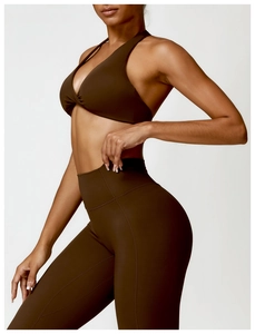 Détail de la brassière de yoga dos nu marron foncé et du legging taille haute sur modèle