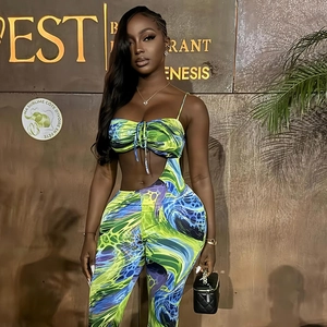 Détail du tissu à imprimé abstrait vert et bleu sur le crop top et le pantalon taille haute