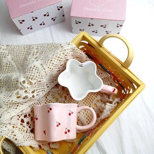 Pink and white cherry ceramic star-shaped mugs with floral edges in a woven basket
