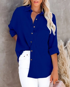 Detail of royal blue linen texture shirt featuring amber buttons and a front pocket
