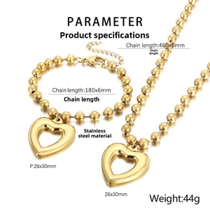 Detailed view of golden heart-shaped necklace and bracelet set with beaded steel chain