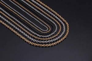 Polished titanium steel tassel necklaces in gold, silver, and black on a dark background