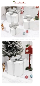 Three-piece set of white Christmas gift boxes with silver glitter bows on a plush carpet