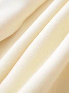 Detailed view of soft cream-colored fleece fabric texture and premium warm knit material