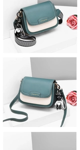 Detail of green and beige saddle bag with herringbone strap and bear charm