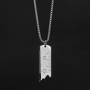 Collier avec pendentif en forme de règle cassée en acier titane sur fond noir chic