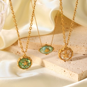 18K gold plated stainless steel necklaces with starfish and seashell charms on silk background