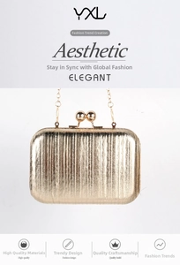 Detail of gold pleated clutch with vertical texture, metal chain and ball clasp closure