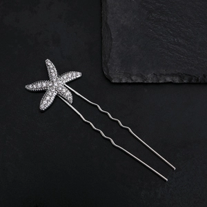 Silver starfish U-shaped hair pin with rhinestones on a textured black background