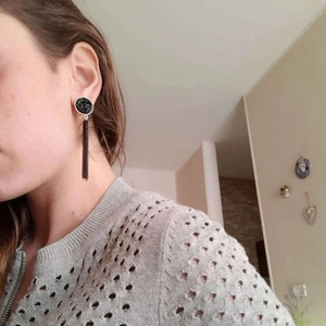 Elegant black tassel drop earrings with gold metal rim shown on model for women