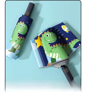 Close-up of automatic folding umbrella with navy blue cartoon dinosaur patterns