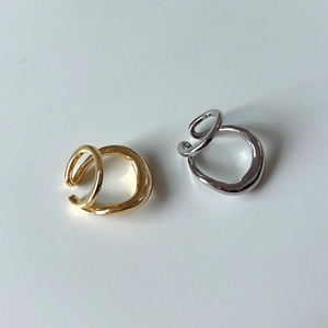 Macro detail of irregular S925 sterling silver ear cuffs in gold and silver mirror finish