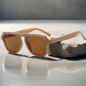 Fashionable oversized retro sunglasses with light brown resin frame on grey stone texture