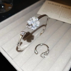 Dettaglio del set bracciale e anello a fiore in zircone argento su vassoio di velluto