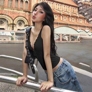 Dettaglio di un sexy top nero con scollo a V profondo e lacci abbinato a jeans in strada
