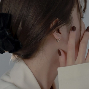 Minimalist silver twisted geometric hoop earrings shown on a model for a stylish look