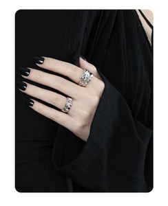 Detailed close-up of irregular lava texture rings with silver glossy finish on hand