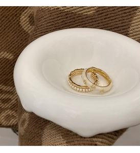 Detail of vintage French style gold rings with cream enamel floral patterns and pearls