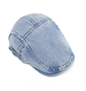 Detail of light blue denim newsboy cap with adjustable metal buckle and stitching