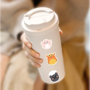 Close-up of cute cartoon stickers on a matte cream-colored portable coffee tumbler