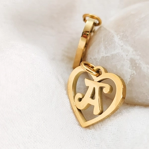 Detailed macro view of gold-plated stainless steel heart pendant with hollow letter A design