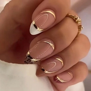 Close-up of nude oval press-on nails with golden metallic waves and leopard patterns