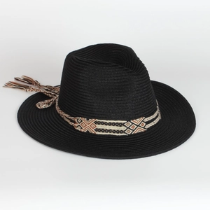 Detail of black straw beach hat featuring ethnic geometric band with tassel accents