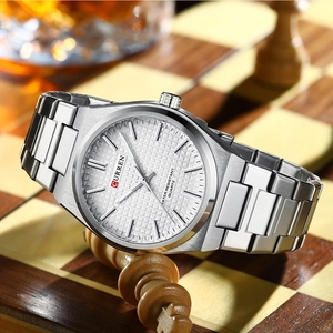 Detailed close-up of a silver Curren business quartz watch on a wooden chessboard
