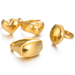 Detail view of four gold stainless steel rings with heart and oval geometric shapes