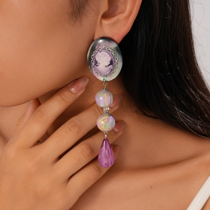 Detail of vintage cameo earrings with purple resin beads and silver chain on model