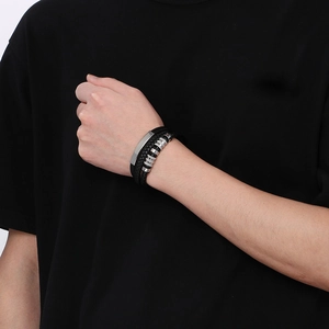 Close-up of multilayer braided black leather bracelet with brushed steel metal beads