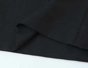 Macro du tissu en toile noire lourde montrant la texture dense et l'épaisseur du costume
