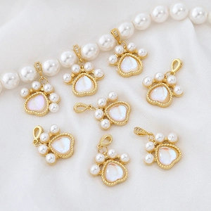 Gold-plated cat paw pendant with pearl accents on a white silk background for DIY jewelry