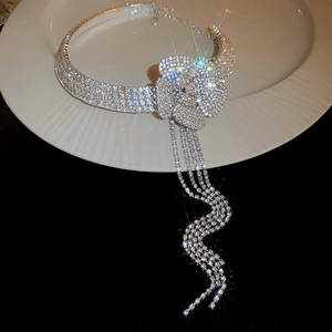 Dettaglio girocollo a fiori in argento con lunghe nappe e strass scintillanti