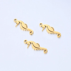 Macro view of three gold polished stainless steel seahorse pendants with hollow details