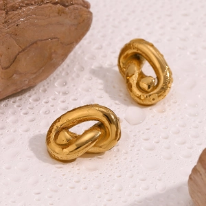 Macro shot of 18K gold plated chunky knot earrings on white surface with water droplets