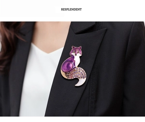 Detailed view of fox brooch with purple enamel and crystals on black blazer lapel