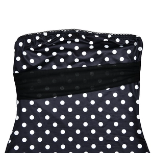 Detailed view of polka dot strapless dress featuring black mesh waist trim and smooth fabric