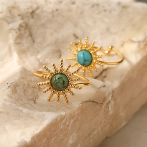 French style sunburst titanium steel rings with inlaid turquoise on a beige stone
