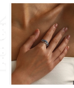 Detailed view of silver mermaid tail ring with blue stones and diamonds on finger
