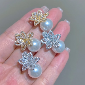 Detailed close-up of luxury flower pearl earrings in gold and silver plating options